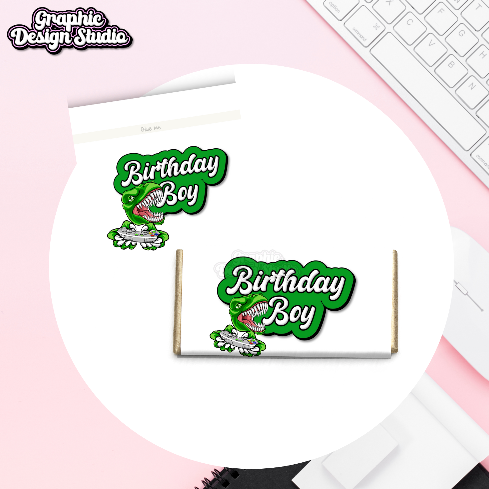 Dinosaur-themed 'Birthday Boy' party favor bags on a pink surface with a keyboard.