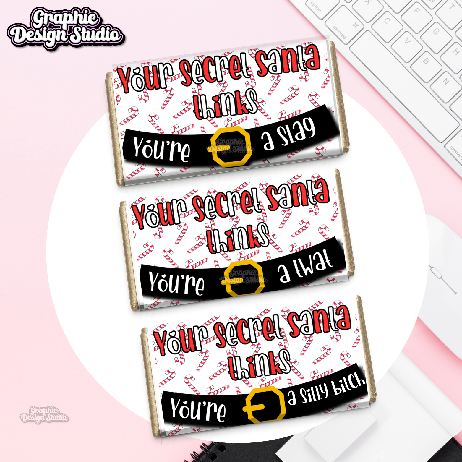 Three chocolate bars with humorous Secret Santa messages on a pink surface.